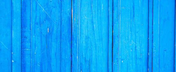 Wooden protection on all background, is painted light blue. old cracked blue paint on wood flooring.