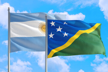 Solomon Islands and Argentina national flag waving in the windy deep blue sky. Diplomacy and...