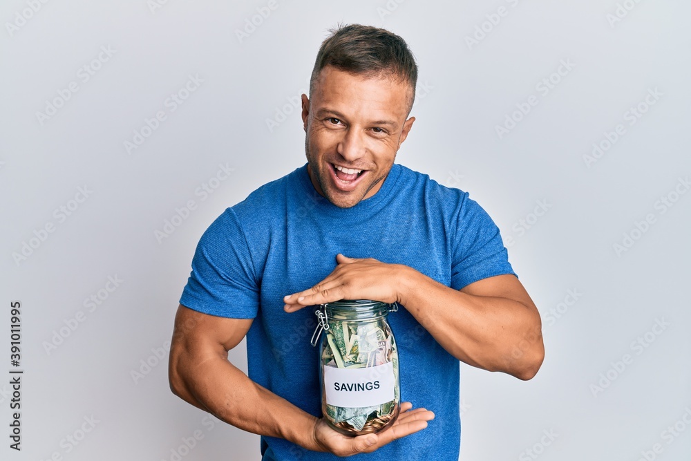 Sticker handsome muscle man holding jar with savings smiling and laughing hard out loud because funny crazy 