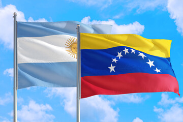 Venezuela and Argentina national flag waving in the windy deep blue sky. Diplomacy and international relations concept.