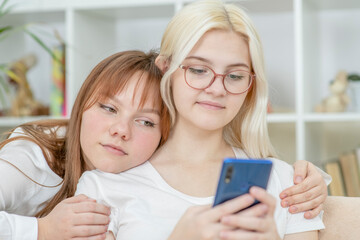 Happy lesbian couple embracing and using smartphone.  Lesbian couple concept