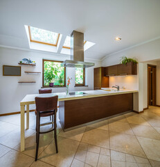 Contemporary interior of kitchen in luxury apartment. Wooden kitchen set. Tile floor. Private house.