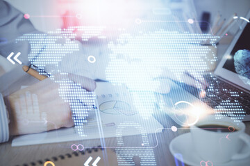 Multi exposure of world map hologram with man working on computer on background. Concept of worldwideweb.