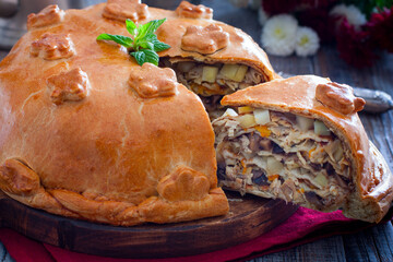 Festive Russian pie kurnik with pancakes, chicken and potatoes, cut off piece with layers of filling, horizontal © Анна Журавлева