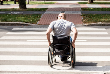 Handicapped man in wheelchair crossing street road