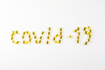 covid -19 laid out in the form of capsules with vitamin D  on a white background