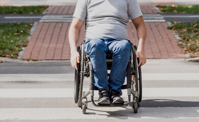 Handicapped man in wheelchair crossing street road