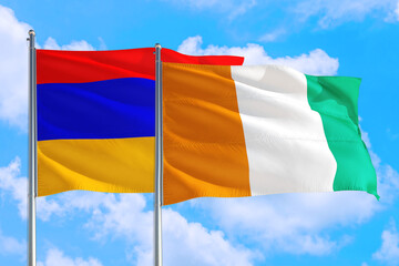 Cote D'Ivoire and Armenia national flag waving in the windy deep blue sky. Diplomacy and international relations concept.