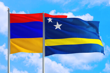 Curacao and Armenia national flag waving in the windy deep blue sky. Diplomacy and international relations concept.
