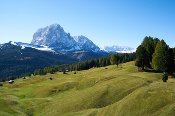 Beautiful langkofel mountain in the dolomites seen from the seceda alm with the first snow white and blue sky