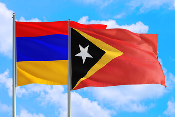 East Timor and Armenia national flag waving in the windy deep blue sky. Diplomacy and international relations concept.