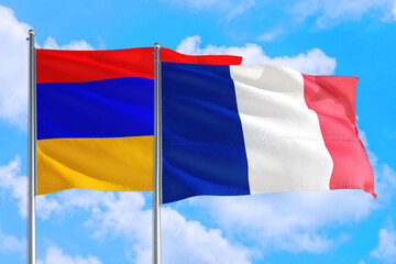 France and Armenia national flag waving in the windy deep blue sky. Diplomacy and international relations concept.