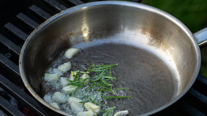 roasting garlic and rosemary in a frying pan for meat sauce. cooking spices.