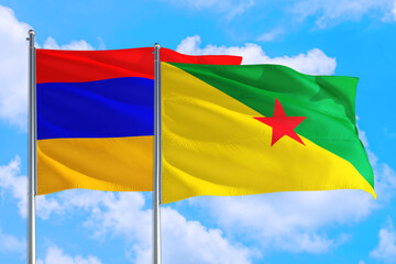 French Guiana and Armenia national flag waving in the windy deep blue sky. Diplomacy and international relations concept.
