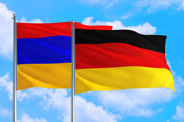 Germany and Armenia national flag waving in the windy deep blue sky. Diplomacy and international relations concept.