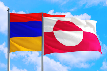 Greenland and Armenia national flag waving in the windy deep blue sky. Diplomacy and international relations concept.