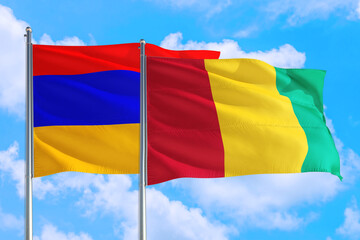 Guinea Bissau and Armenia national flag waving in the windy deep blue sky. Diplomacy and international relations concept.