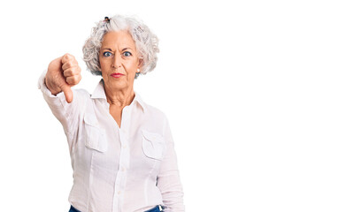 Senior grey-haired woman wearing casual clothes looking unhappy and angry showing rejection and negative with thumbs down gesture. bad expression.