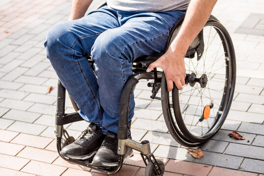 Handicapped man in wheelchair walk at the park alley