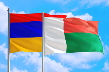 Madagascar and Armenia national flag waving in the windy deep blue sky. Diplomacy and international relations concept.