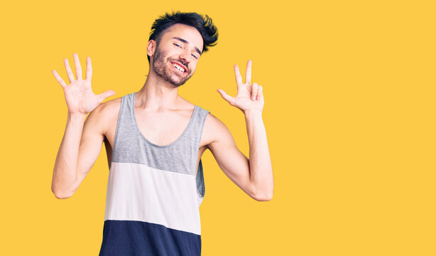 Young hispanic man wearing casual clothes showing and pointing up with fingers number eight while smiling confident and happy.