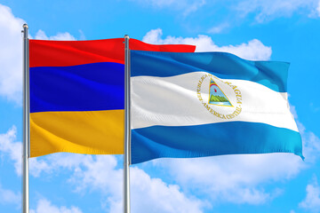 Nicaragua and Armenia national flag waving in the windy deep blue sky. Diplomacy and international relations concept.