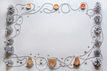 rectangular frame on a light background with silver cones candles and silver stars