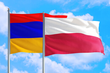 Poland and Armenia national flag waving in the windy deep blue sky. Diplomacy and international relations concept.