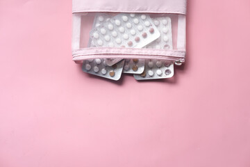 birth control pills on pink background, Top view 