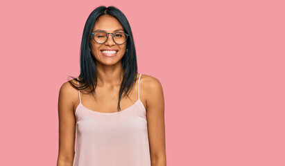 Young african american woman wearing casual clothes and glasses winking looking at the camera with...