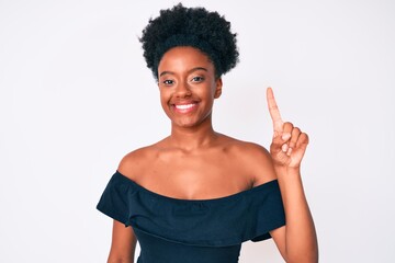 Young african american woman wearing casual clothes showing and pointing up with finger number one while smiling confident and happy.