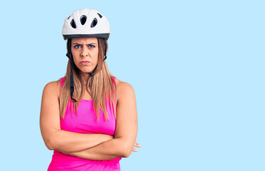Young beautiful woman wearing bike helmet skeptic and nervous, disapproving expression on face with crossed arms. negative person.