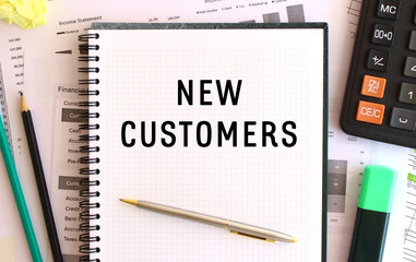 Notepad with text NEW CUSTOMERS on a white background, near calculator. Business concept.