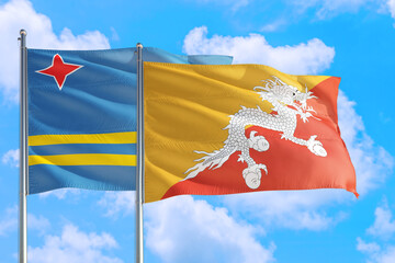 Bhutan and Aruba national flag waving in the windy deep blue sky. Diplomacy and international relations concept.