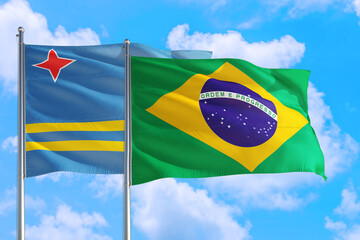 Brazil and Aruba national flag waving in the windy deep blue sky. Diplomacy and international relations concept.