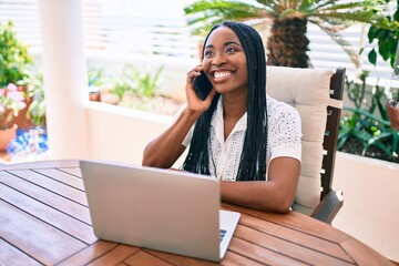 Young african american woman smiling happy using smartphone at terrace