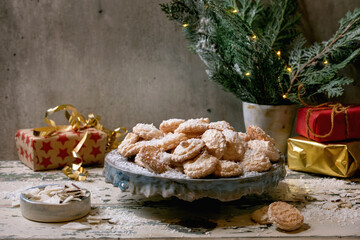 Homemade Christmas coconut gluten free cookies with coconut flakes on ceramic plate on old wooden table with xmas gifts and decorations.