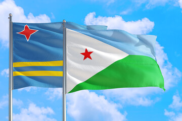 Djibouti and Aruba national flag waving in the windy deep blue sky. Diplomacy and international relations concept.
