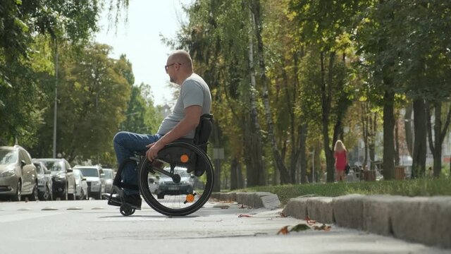 Handicapped man in wheelchair crossing street road