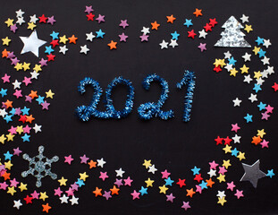 New Year 2021festive  background  with multicolored stars and numbers made of tinsel.