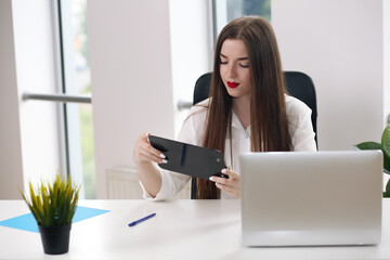 young brunette businesswoman sitting on bright modern workplace