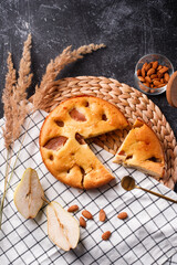 homemade crunchy pear pie on a black background and white tablecloth
