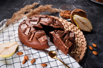 Chocolate cake with chocolate pieces on a metallic black background