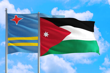 Jordan and Aruba national flag waving in the windy deep blue sky. Diplomacy and international relations concept.