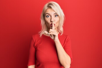 Young blonde girl wearing casual clothes asking to be quiet with finger on lips. silence and secret concept.