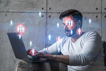 A serious caucasian manager in casual wears, using laptop to develop a new worldwide supply chain. Double exposure. globe and map hologram.