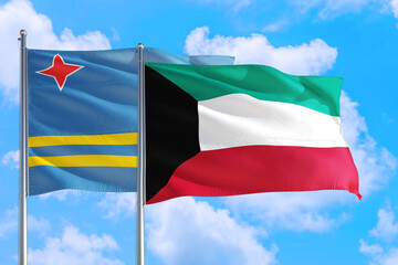 Kuwait and Aruba national flag waving in the windy deep blue sky. Diplomacy and international relations concept.