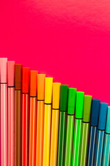 bright background with multi-colored markers on a crimson background. space for text