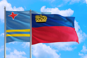 Liechtenstein and Aruba national flag waving in the windy deep blue sky. Diplomacy and international relations concept.