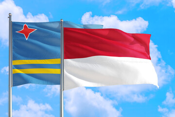 Monaco and Aruba national flag waving in the windy deep blue sky. Diplomacy and international relations concept.